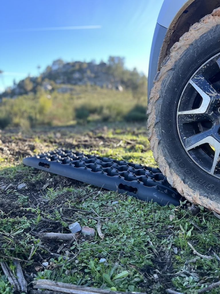 dreckiger AT-Reifen mit Sandblech in der Natur mit Wohnmobil festgefahren